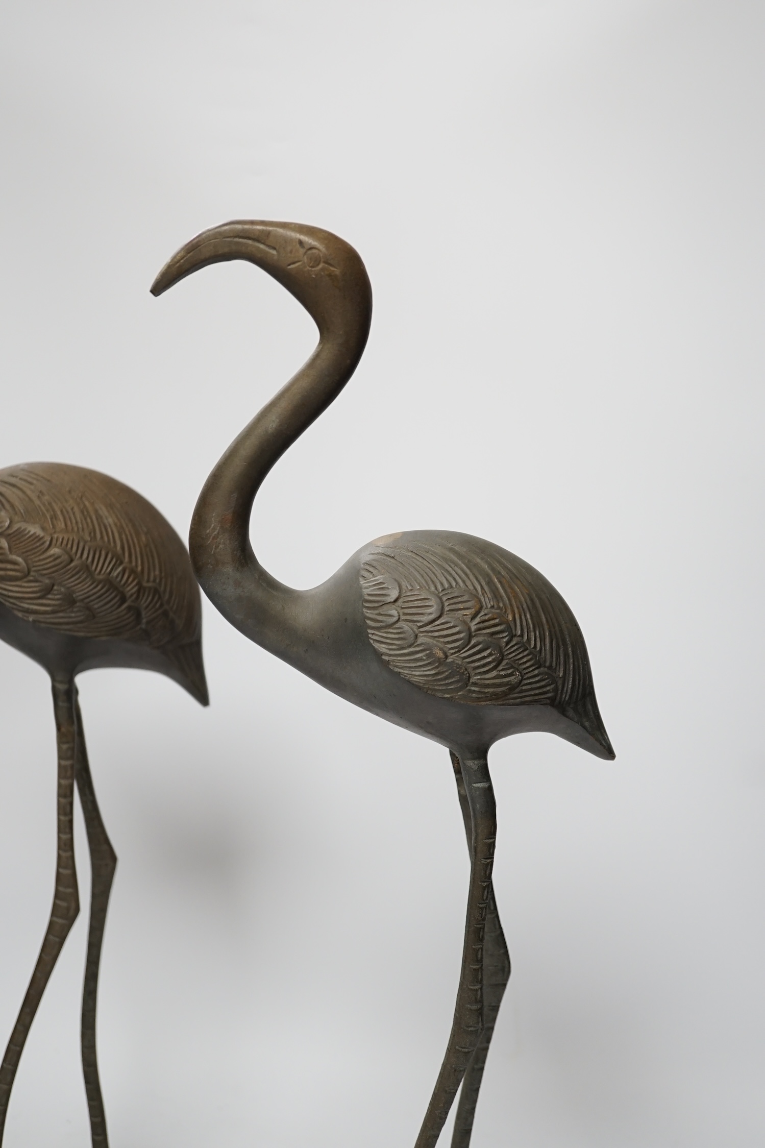 A pair of brass cranes, a pair of brass chamber sticks another chamberstick and a bowl, tallest 53cm high